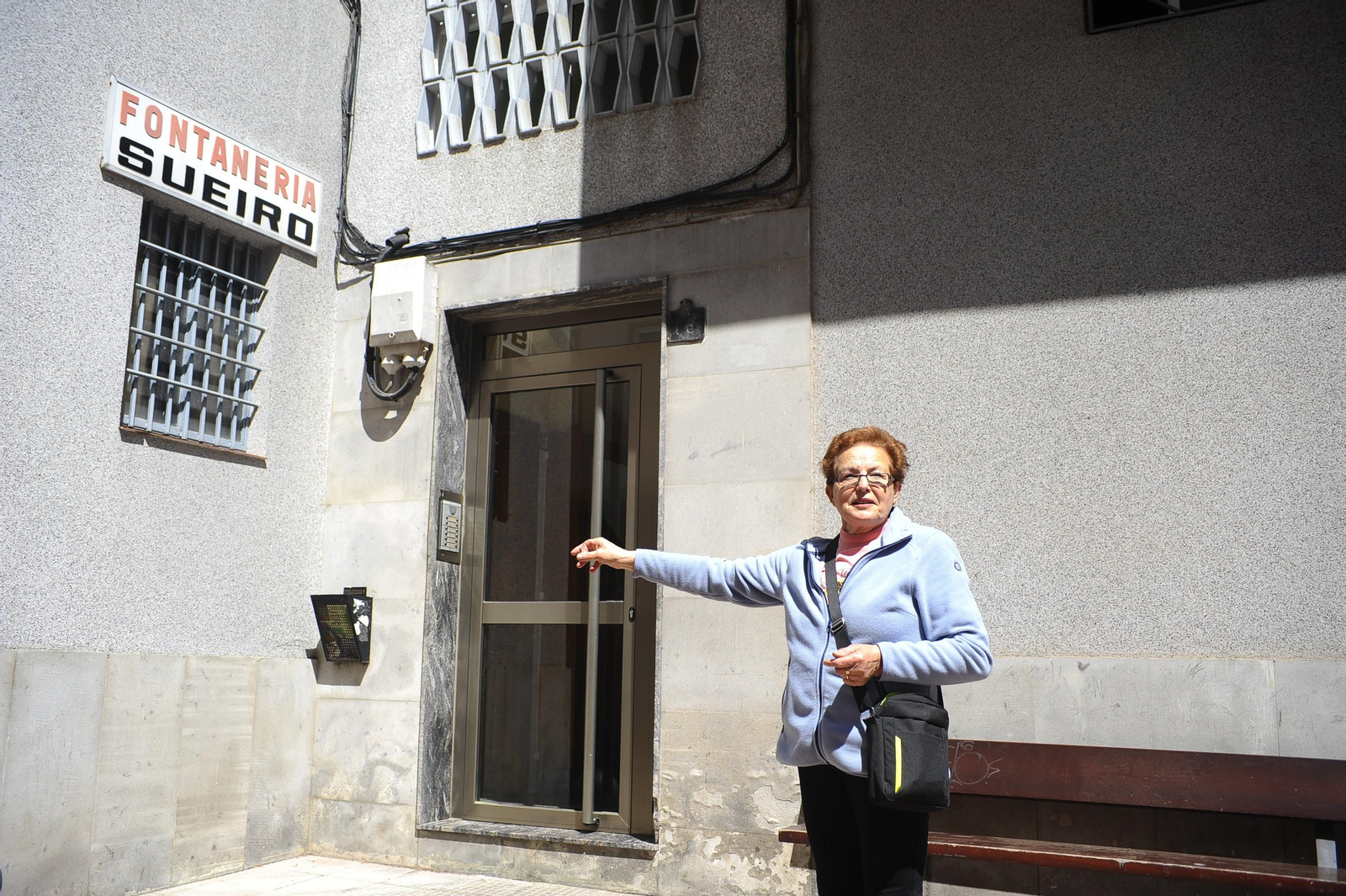 Milagros Iglesias señala la fachada en la que se ubicará el ascensor.
