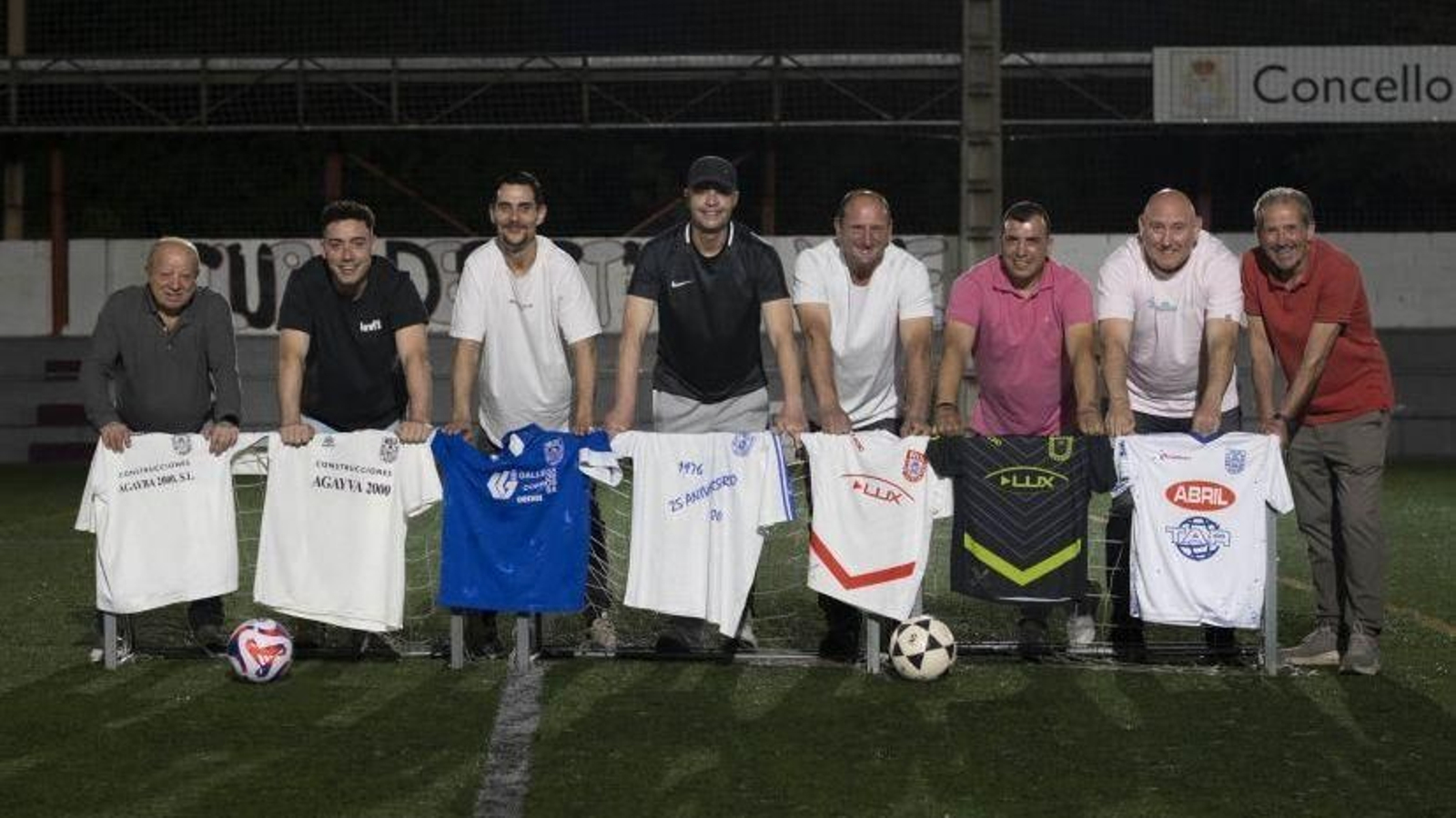 Los exjugadores del Club Deportivo Velle, con varias de las camisetas utilizadas durante su historia, en el campo del Monte da Aira.