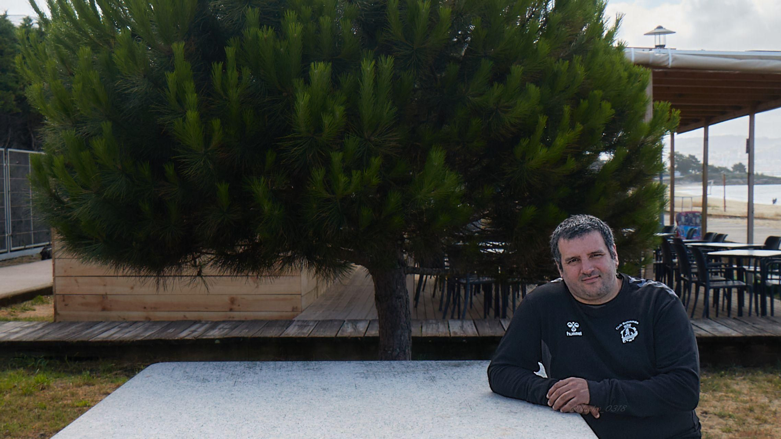 Isma Martínez posa reflexivo baixo un piñeiro que hai na praia de Rodeira, na súa Cangas natal.
