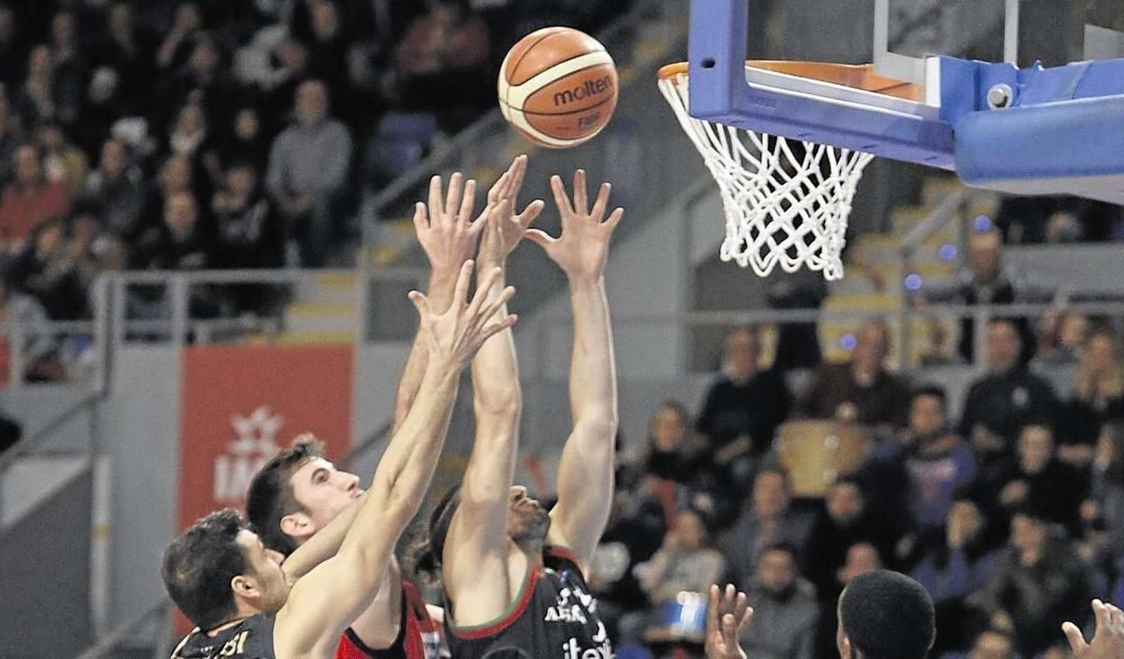 Uclés y Barber pelean por el rebote ante varios rivales del Granada.