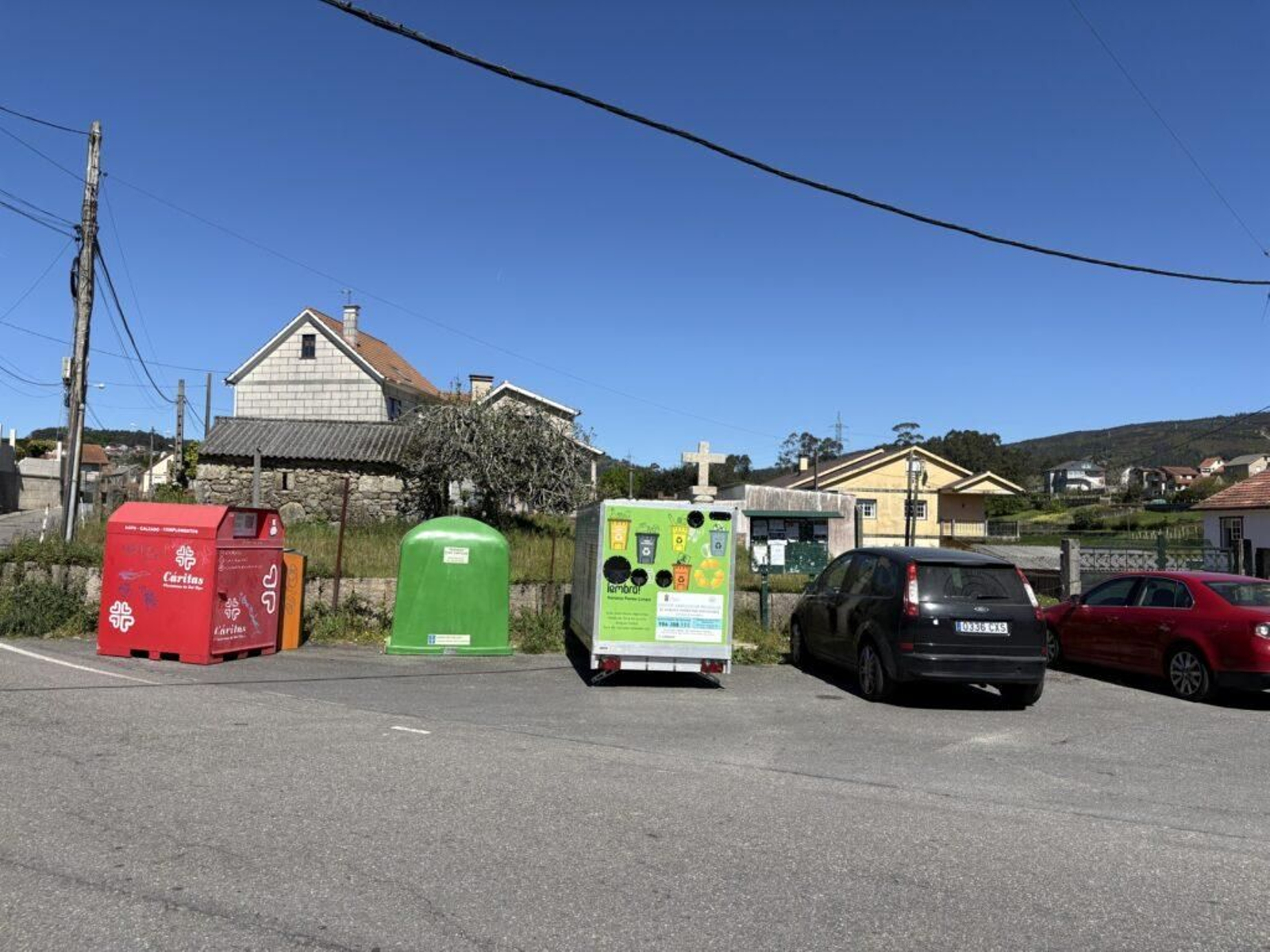 En la imagen, los contenedores y el remolque de reciclaje junto al cruceiro del antiguo torreiro.