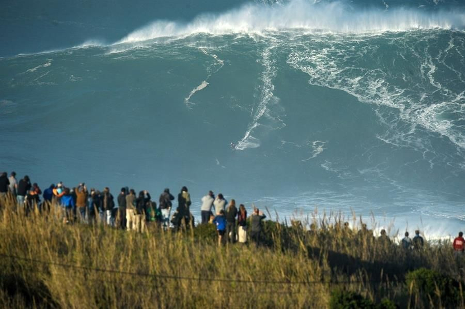 Un surfista monta una de las olas gigantes generadas por el huracán Epsilon en el Atlántico Norte a su llegada a la Praia do Norte, en Nazaré, Portugal, este jueves.EFE/ Carlos Barroso