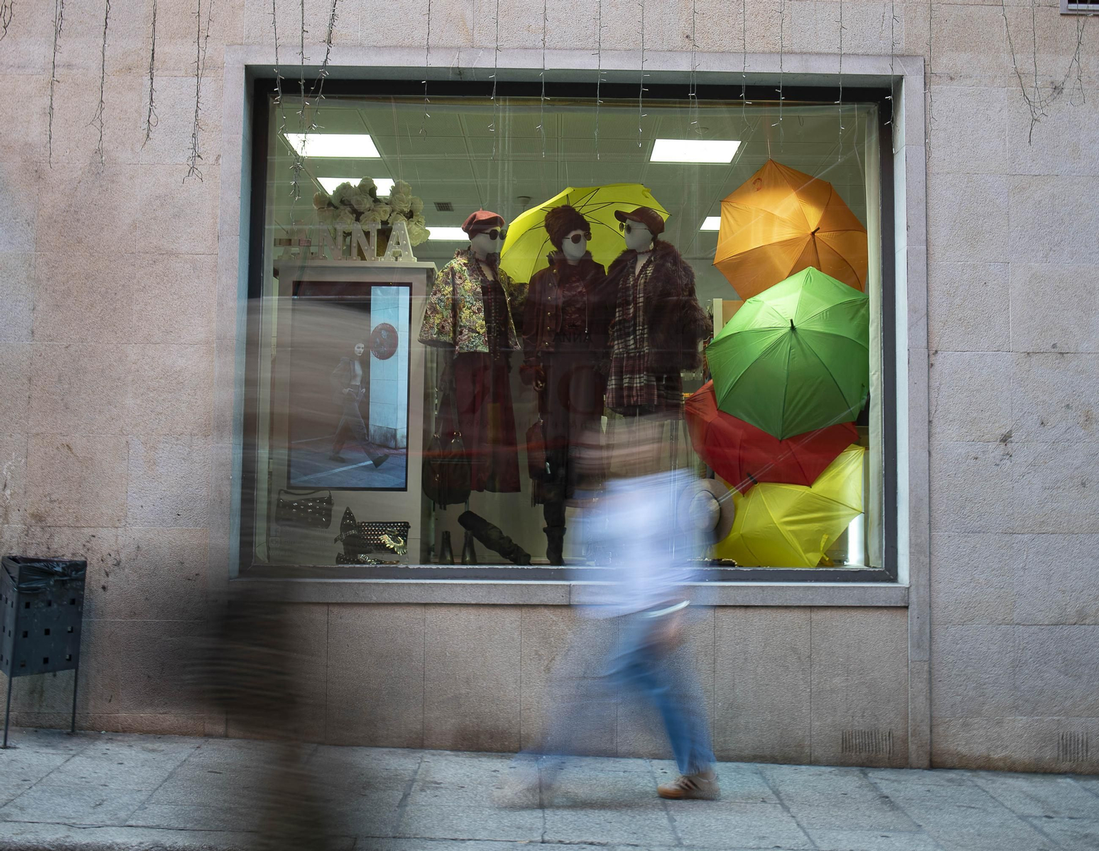 Un escaparate en la calle Santo Domingo con ropa de invierno y paraguas, artículos que los ourensanos aún no han necesitado este otoño.