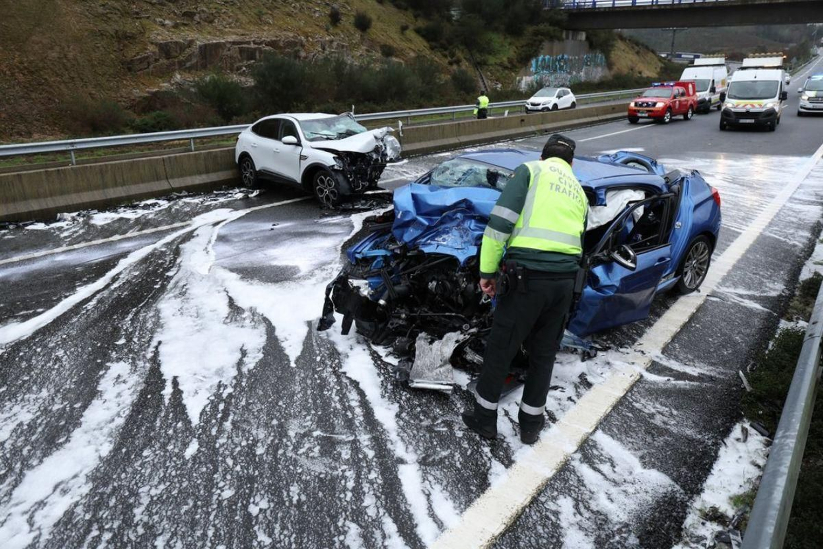Un agente de la Guardia Civil inspecciona el vehiculo que se saltó la mediana en la A-52.