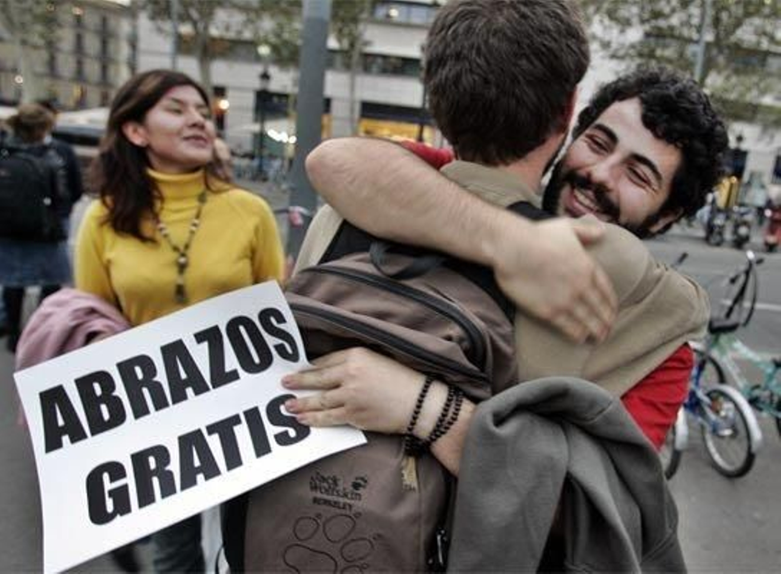 Dos jóvenes se abrazan en la calle.