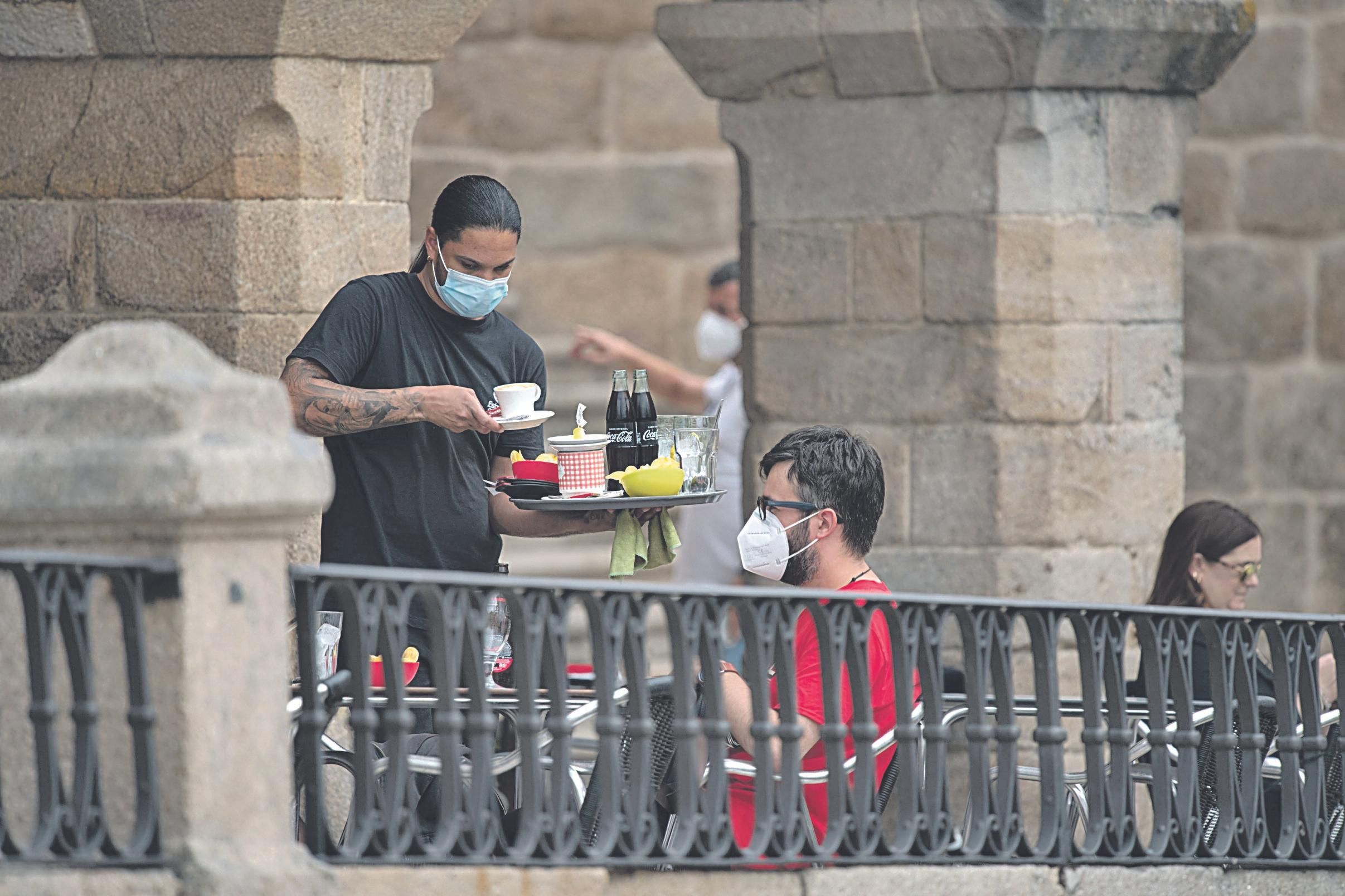 Un camarero sirve una terraza en Ourense. (OSCAR PINAL)