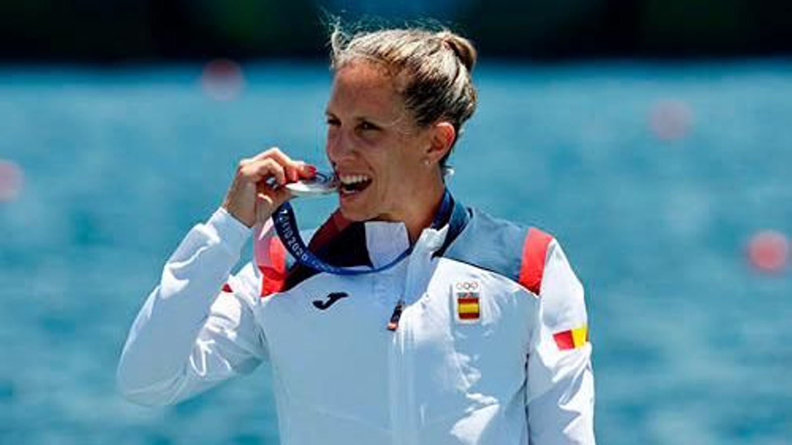 La canguesa Teresa Portela muerde la medalla de plata en el podio de Tokio. // EFE