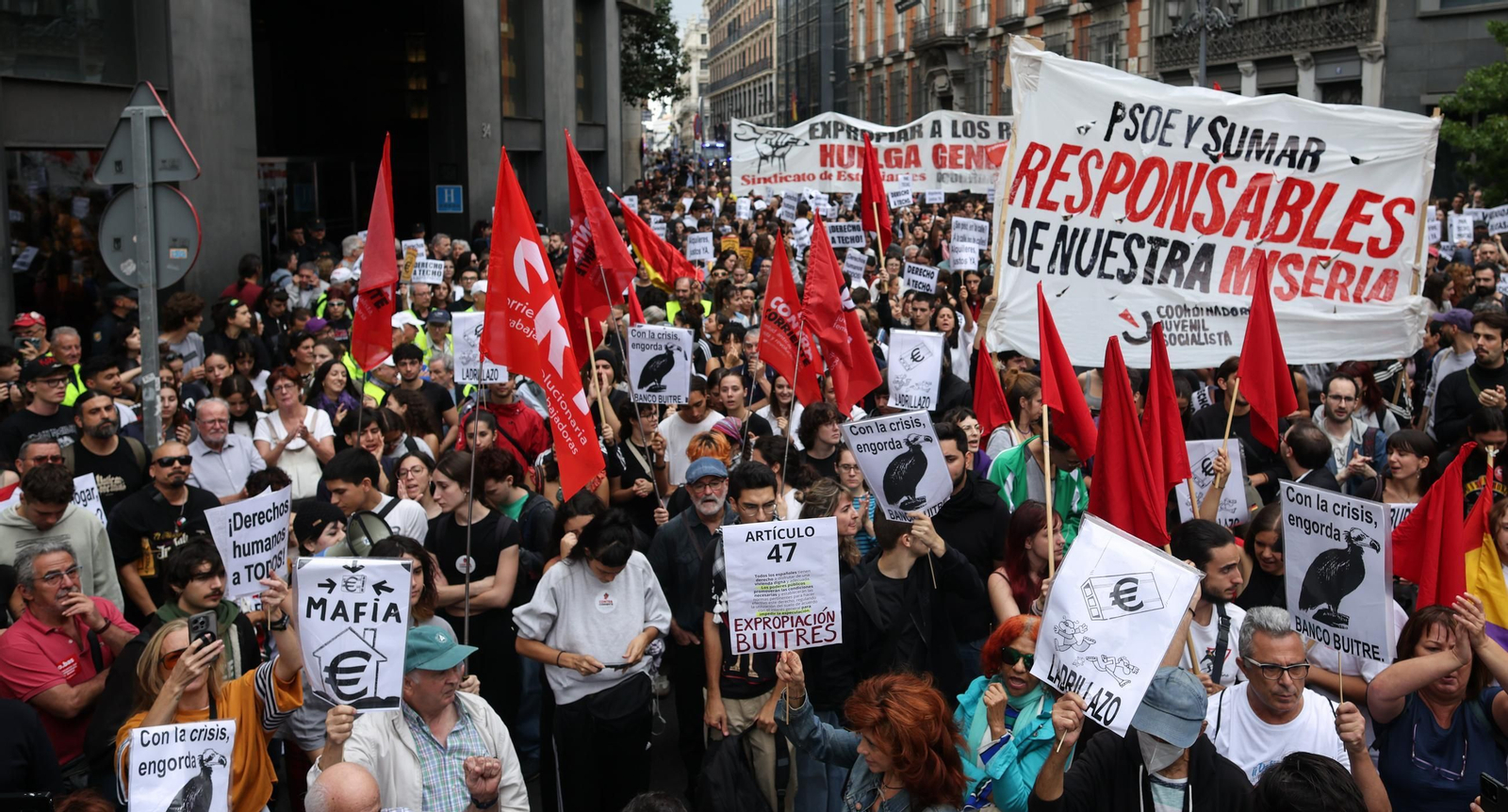 Manifestantes concentrados ante el cordón policial desplegado en los aledaños del Congreso de los Diputados durante la protesta en defensa del derecho a la vivienda