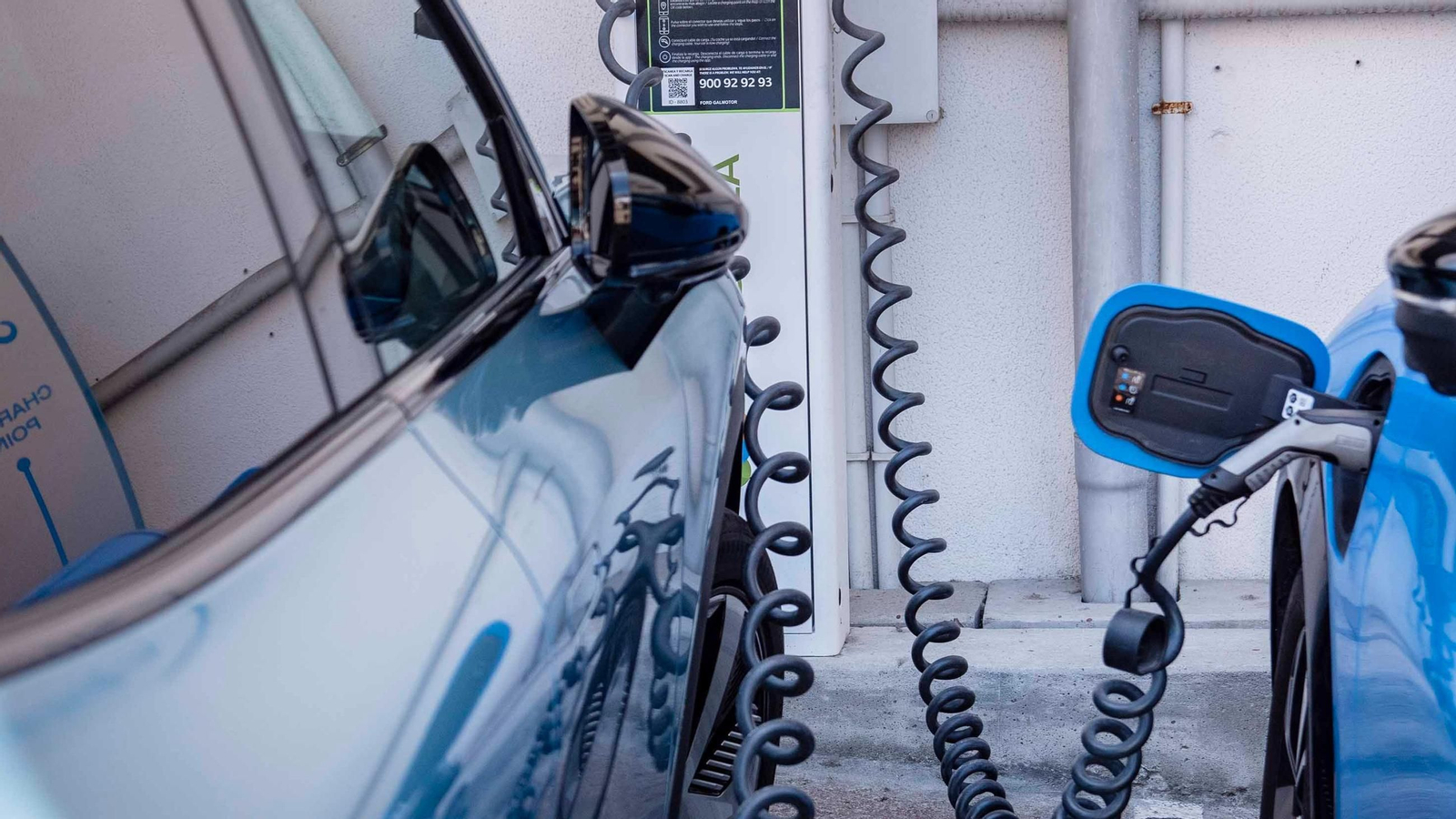 Un coche eléctrico enchufado a un punto de recarga.