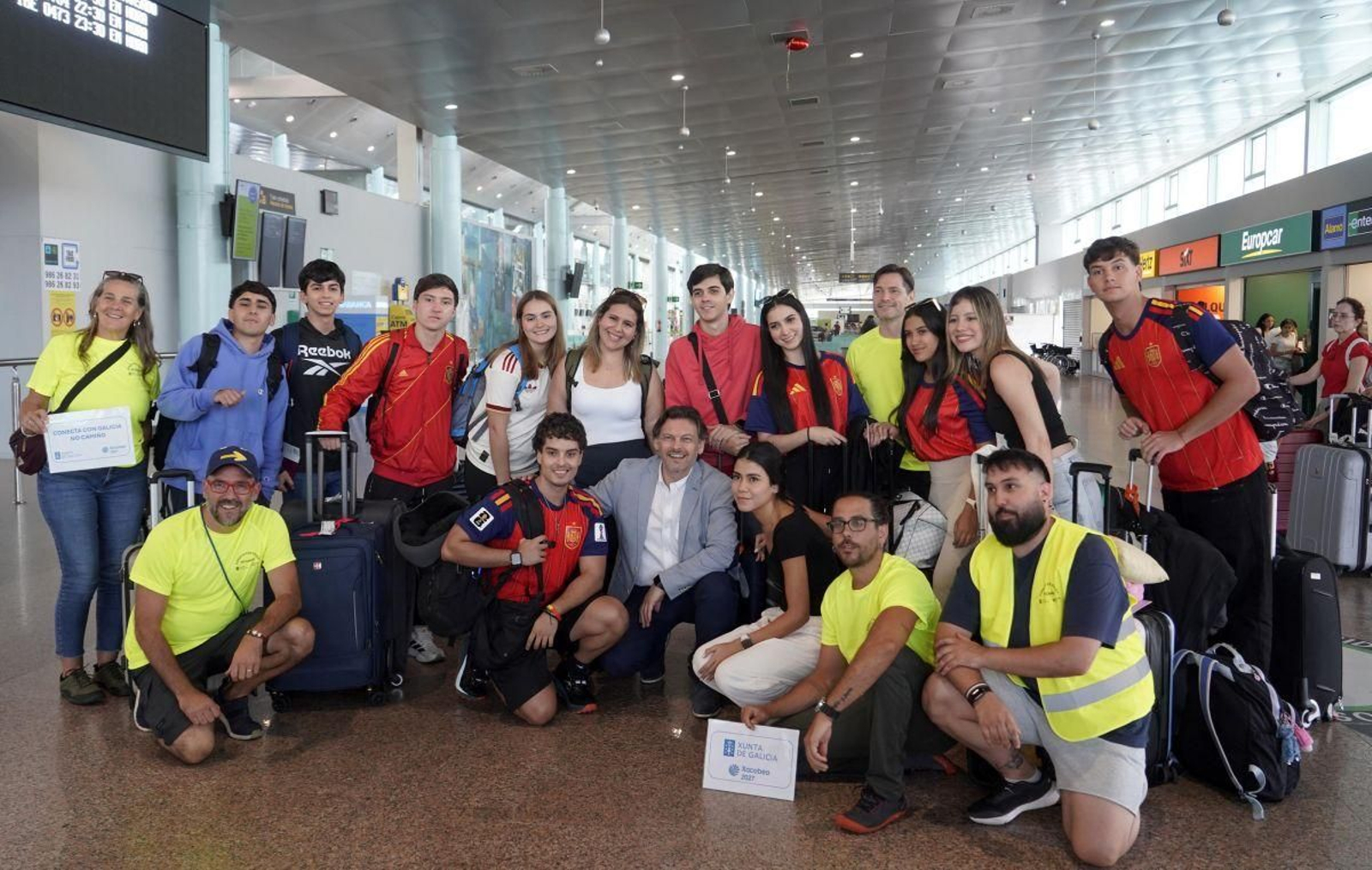 Los jóvenes que llegaron ayer a Peinador, con el secretario xeral de Emigración.
