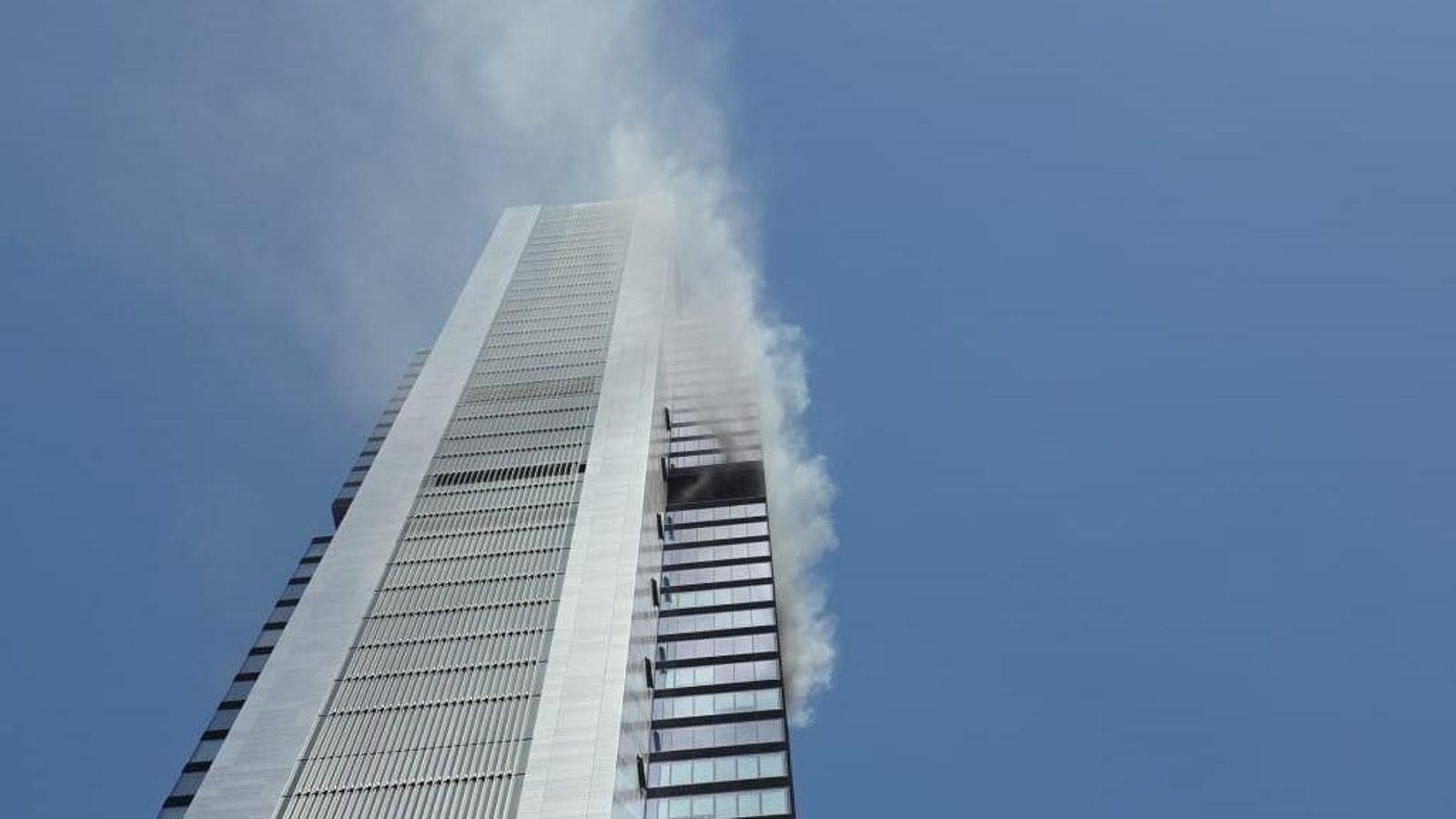 Columna de humo por un incendio en la torre Moeve, en Madrid.