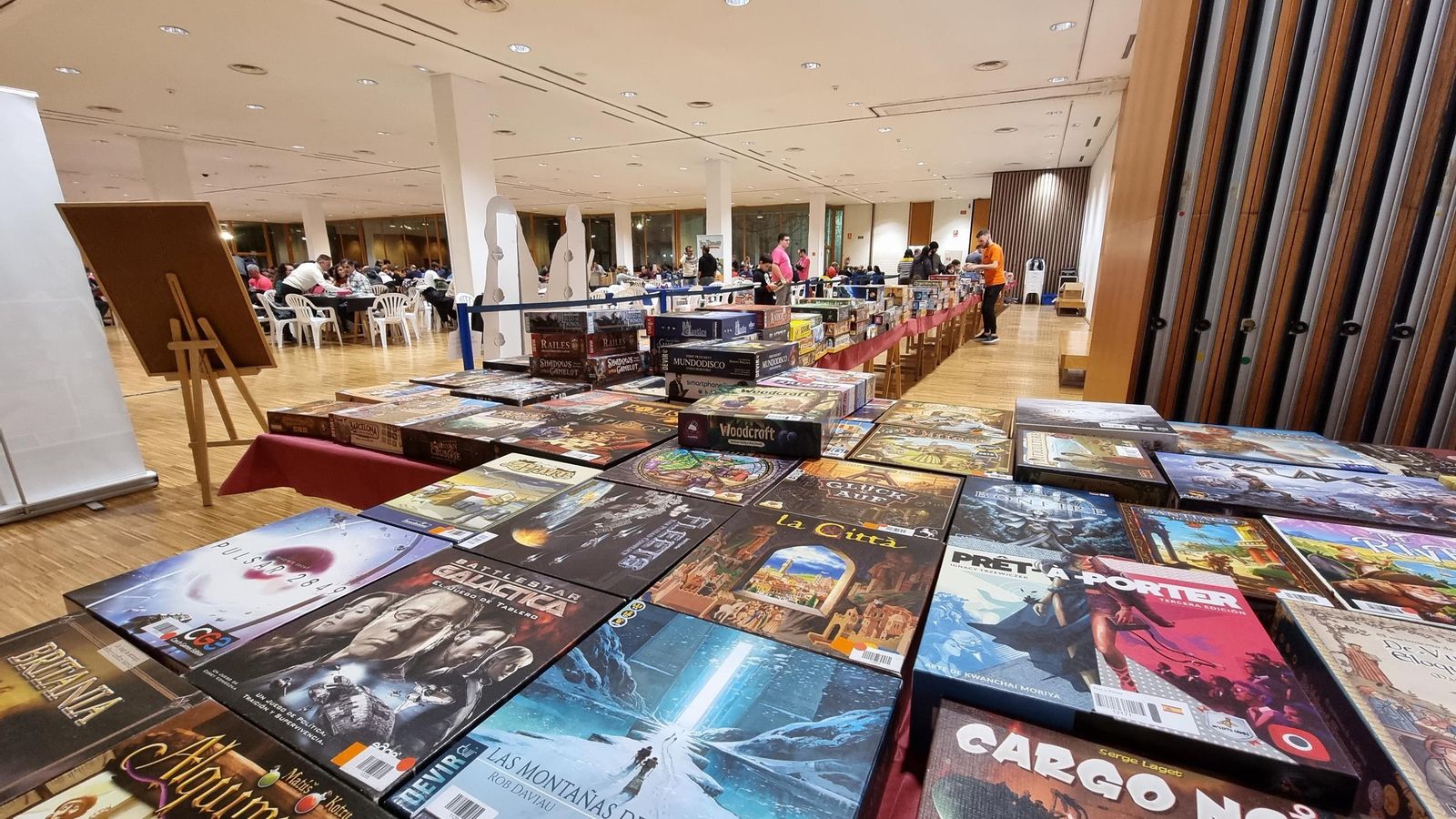 Una mesa repleta de juegos de mesa expuesta en un festival