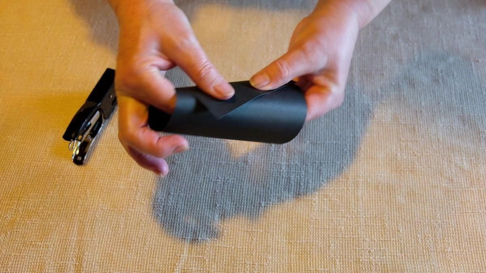 Cando o teñas, fai un tubo e grampa un dos lados. Esta será a parte máis ancha do proxector, polo que antes de grampar o outro lado, enrosca ata que che quede unha especie de cono. Na parte máis estreita é suficiente con deixar un burato no que entre a lanterna. Cando o teñas, grampa tamén este lado.