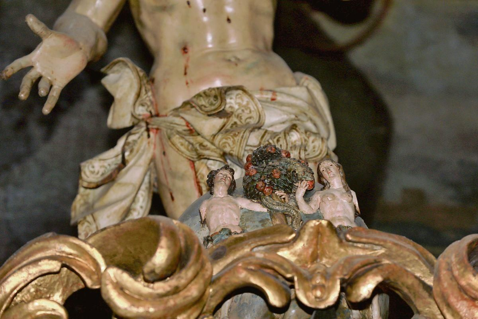 Adan y Eva. El primer hombre y la primera mujer creados por Dios, desnudos junto al árbol del pecado original. Hay que fijarse bien para captarlos al observar el Cristo del Perdón, talla barroca en la parte posterior del baldaquino de la Capilla del Santo Cristo.