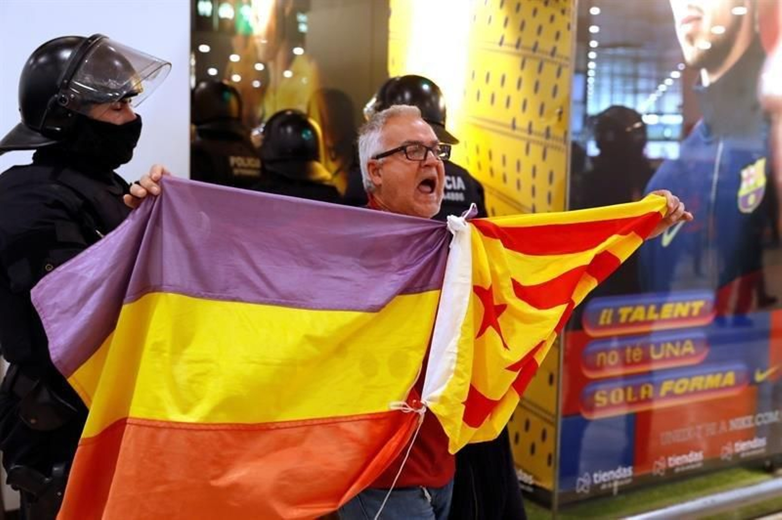 Un manifestante exhibe una bandera republicana y una estelada en la estación de Sants, en Barcelona. (Foto: EFE)