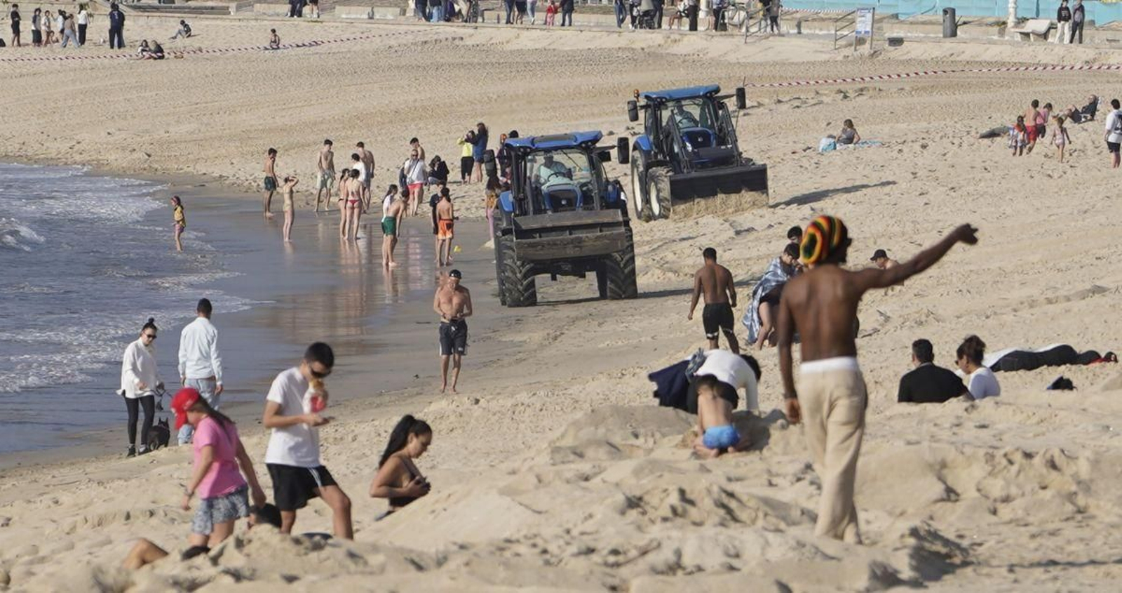Maquinaria trabajando ayer en la playa de Samil, ya con afluencia por el buen tiempo