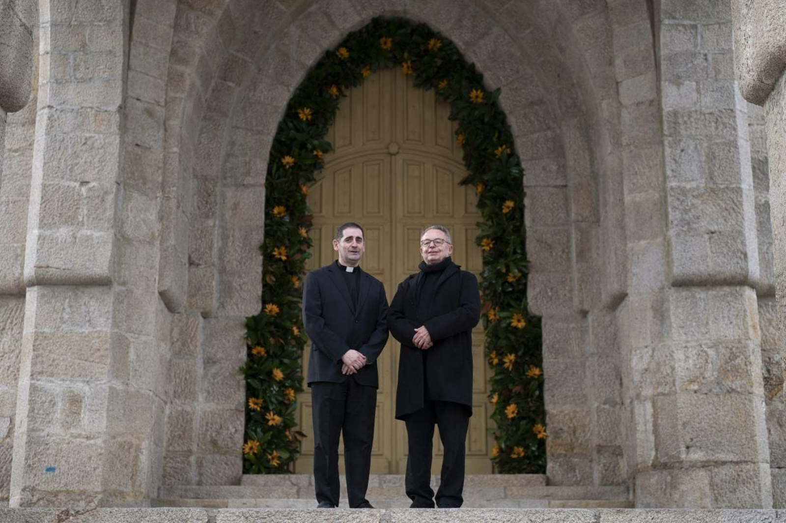 Jorge Pérez y Ricardo Bello delante de la puerta principal del templo.