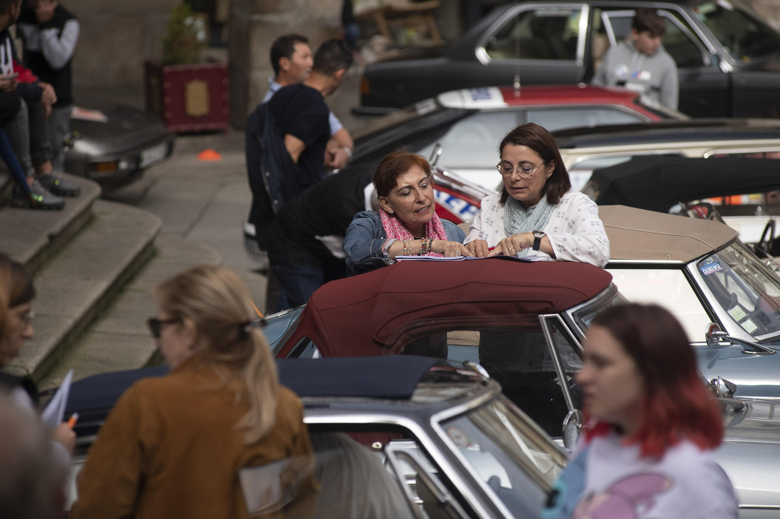 Dos señoras observando un coche de rally clásico en la Plaza Mayor de Ourense