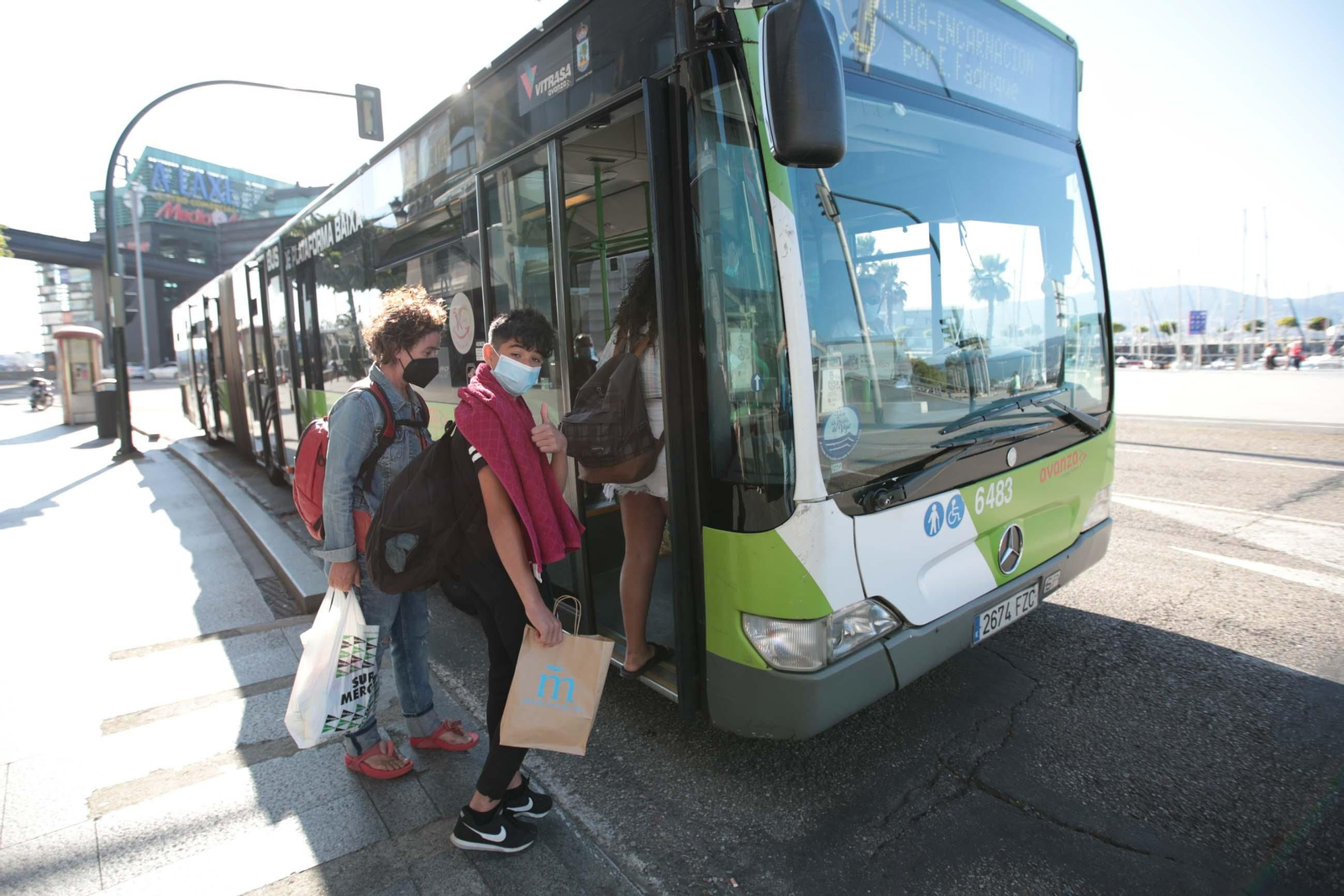 Vigueses con mascarilla se suben a un autobús, ayer. / David Fernández