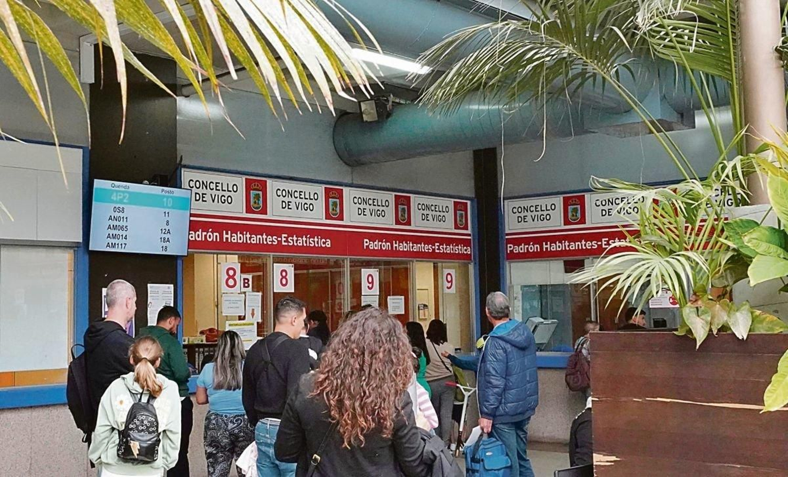 Personas realizando trámites para el padrón en la lonja del Concello.