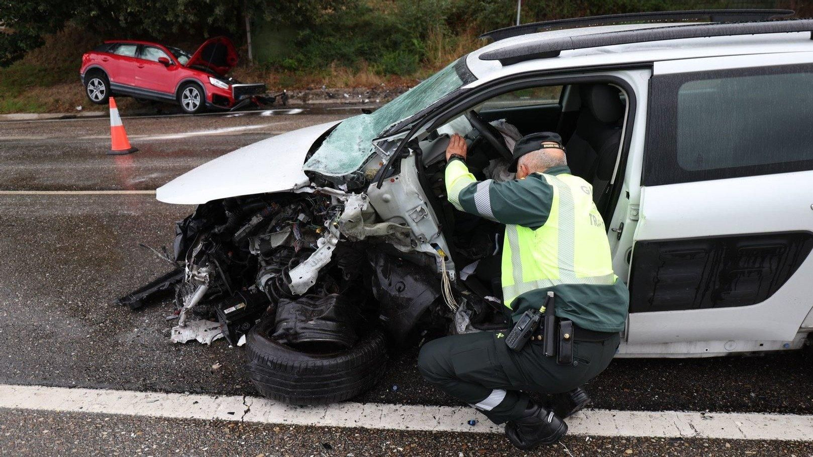 Un agente de la Guardia Civil inspecciona uno de los vehículos accidentados. // Alberte