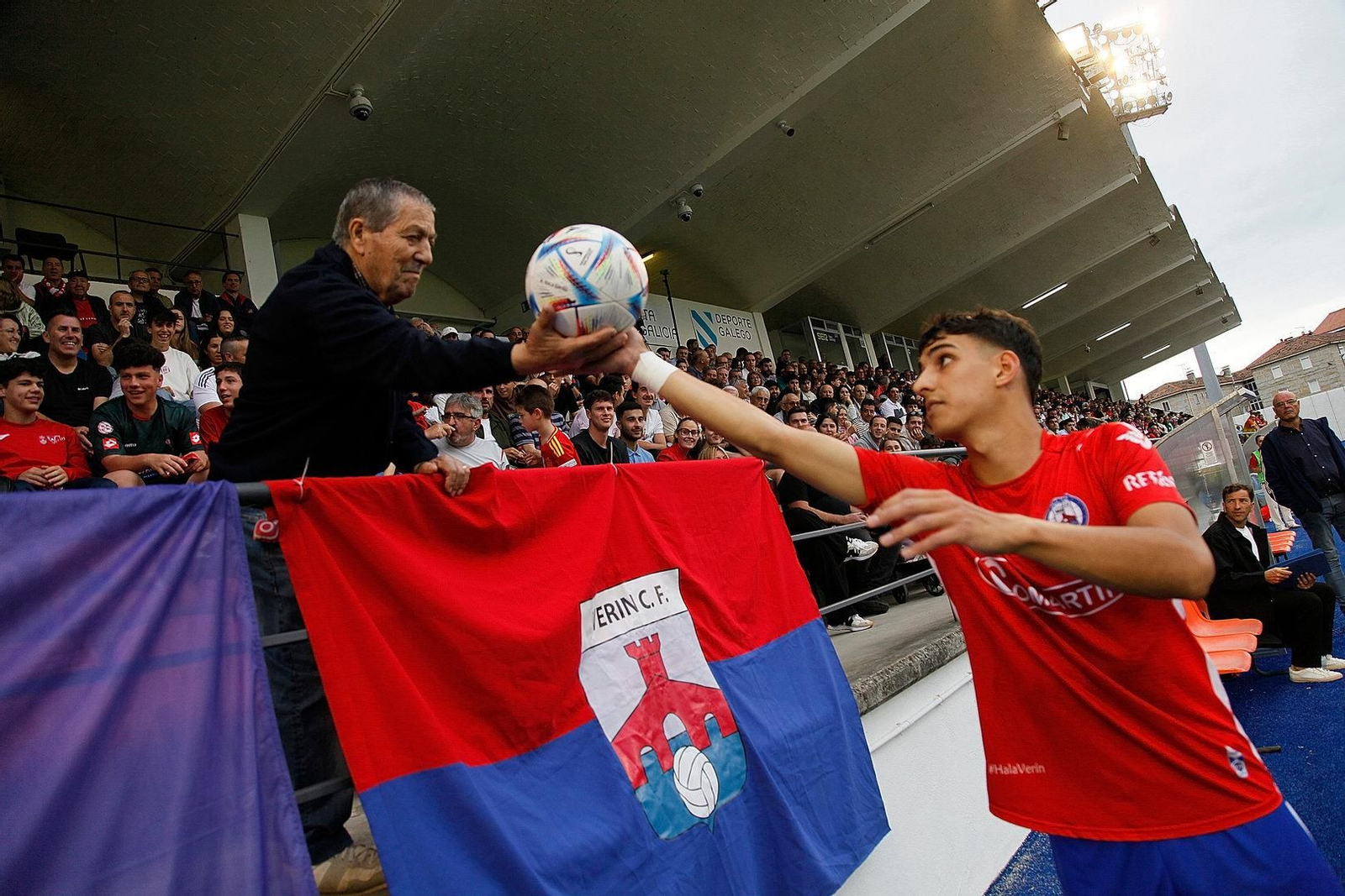 Un espectador entregando el esférico a un jugador del Verín.
