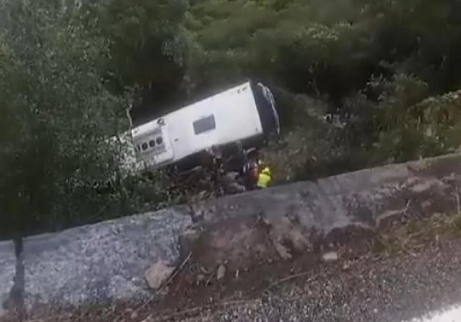 El autobús accidentado en Barcelona y los equipos de emergencia trabajan en el rescate de los heridos.