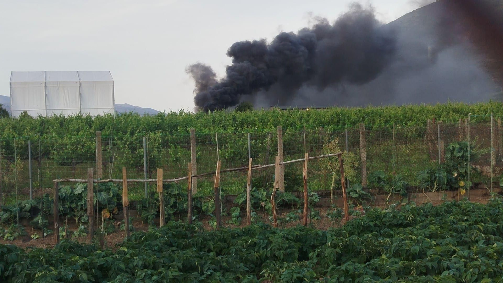 La negra columna de humo producida al arder una lona de plástico en A Rúa