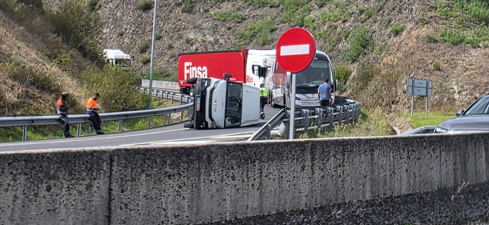 La furgoneta quedó volcada en medio de la calzada tras sufrir el accidente en una curva de la OU-11.