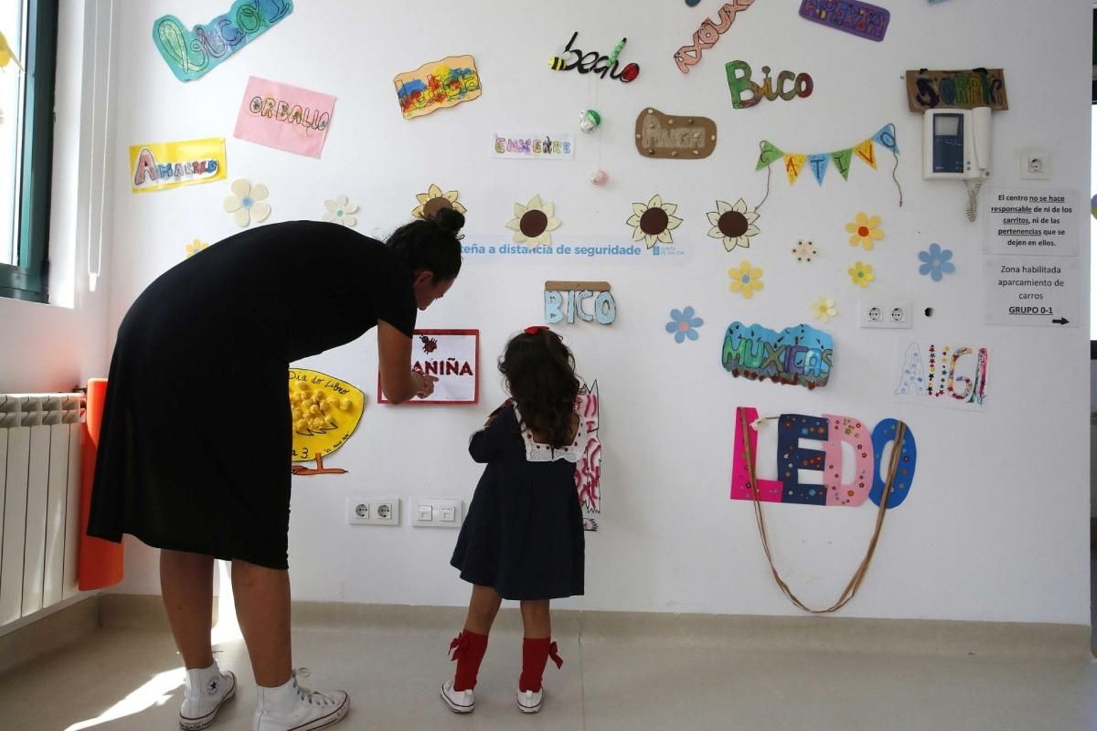 Una profesora de educación infantil enseña a una niña en una guardería.