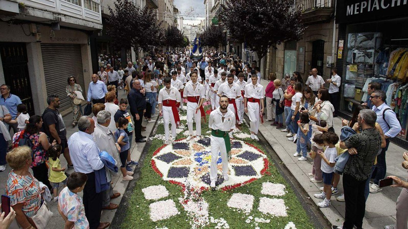 Integrantes de la Danza de la Espadas en el desfile sobre una de las alfombras.