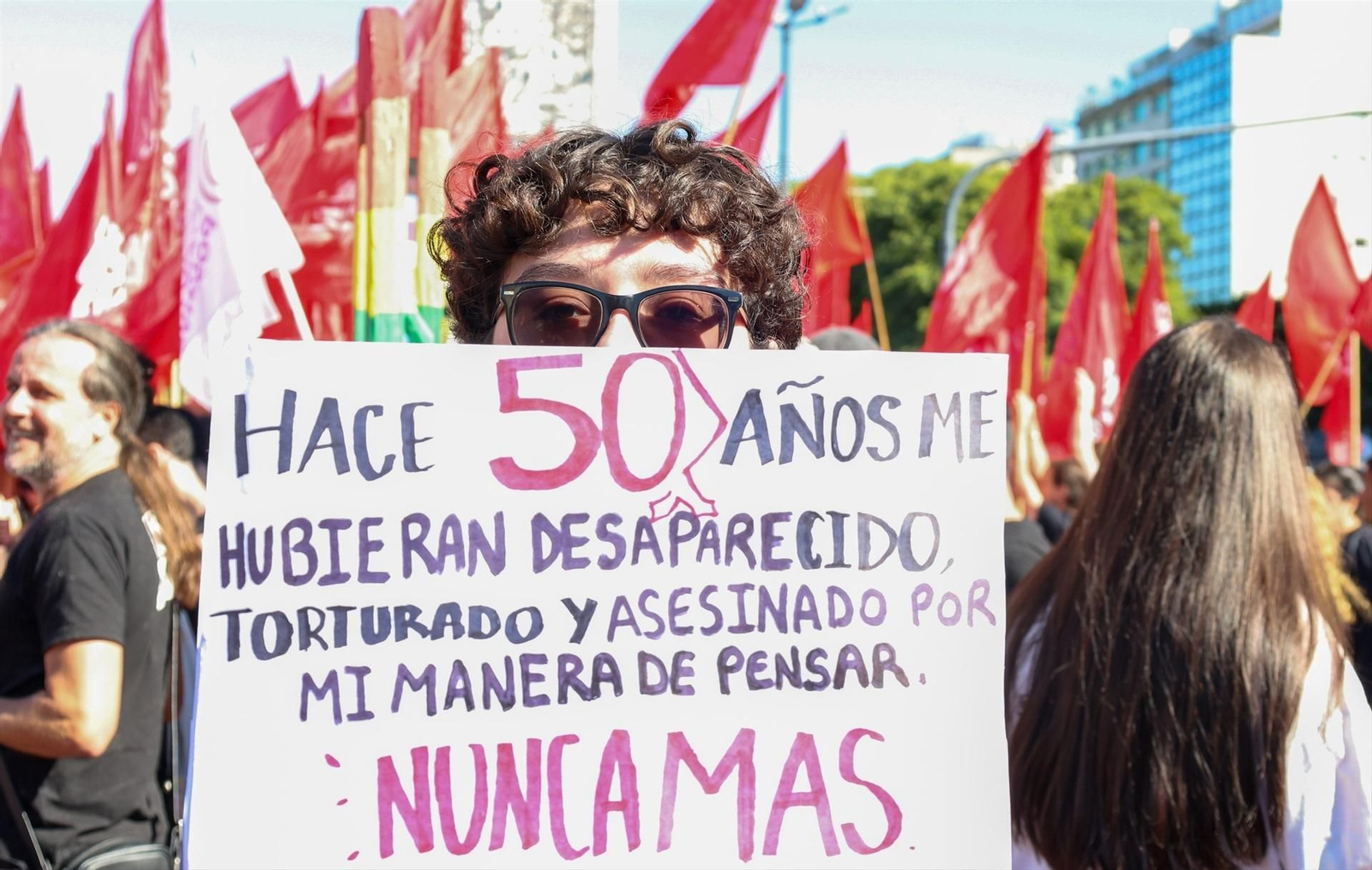Uno de los manifestantes, un joven con una pancarta en la que denuncia los secuestros y maltratos que se realizaron durante la dictadura en Argentina.
