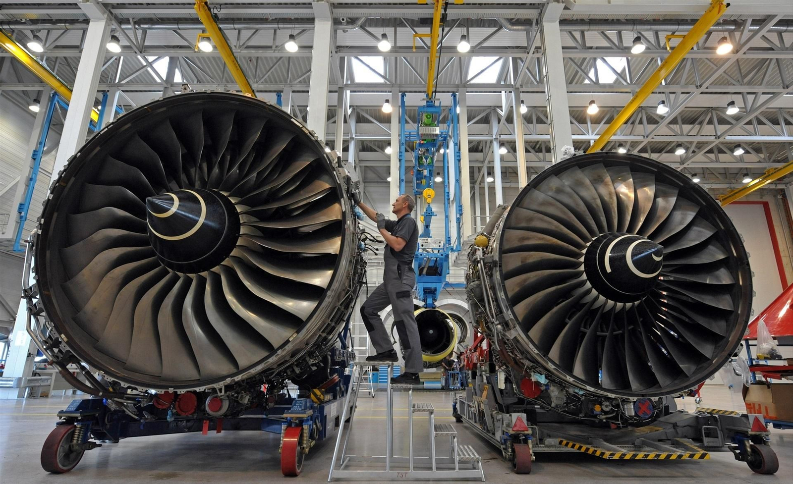 Un empleado trabajando en un motor de entrenamiento para aviones Rolls-Royce Trent 900