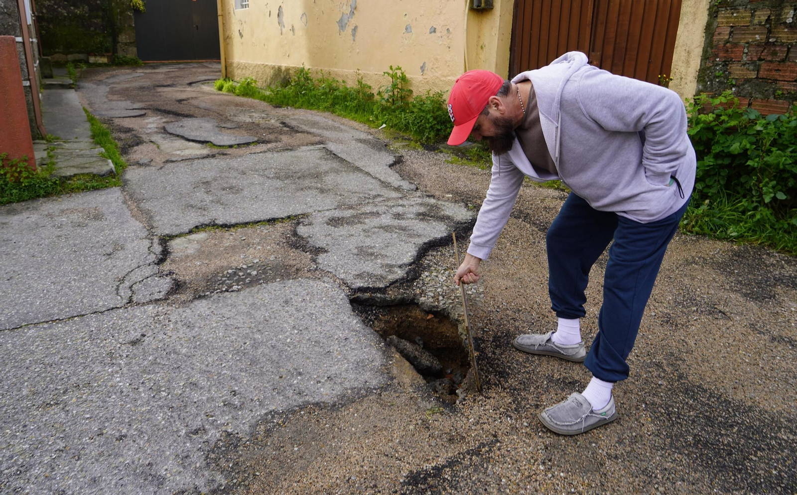 Un vecino de la zona muestra los desperfectos en este tramo de Couto San Honorato.