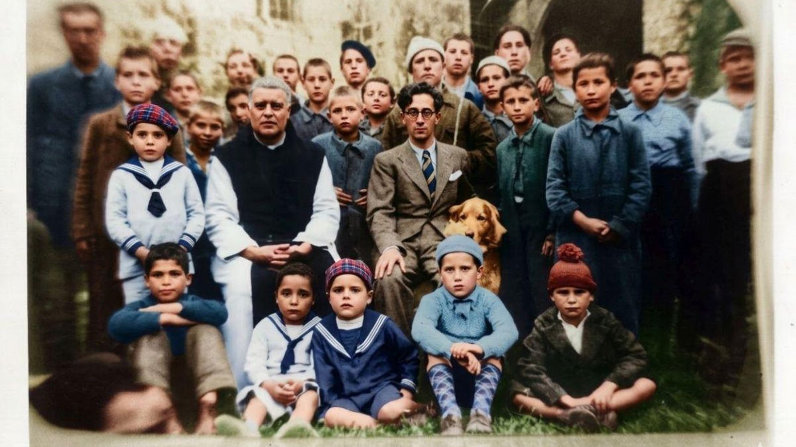 El doctor Antonio Vázquez de Parga-Jorge, posando con los niños del Orfanato de Osera. A su lado asoma la cabeza su fiel perro.