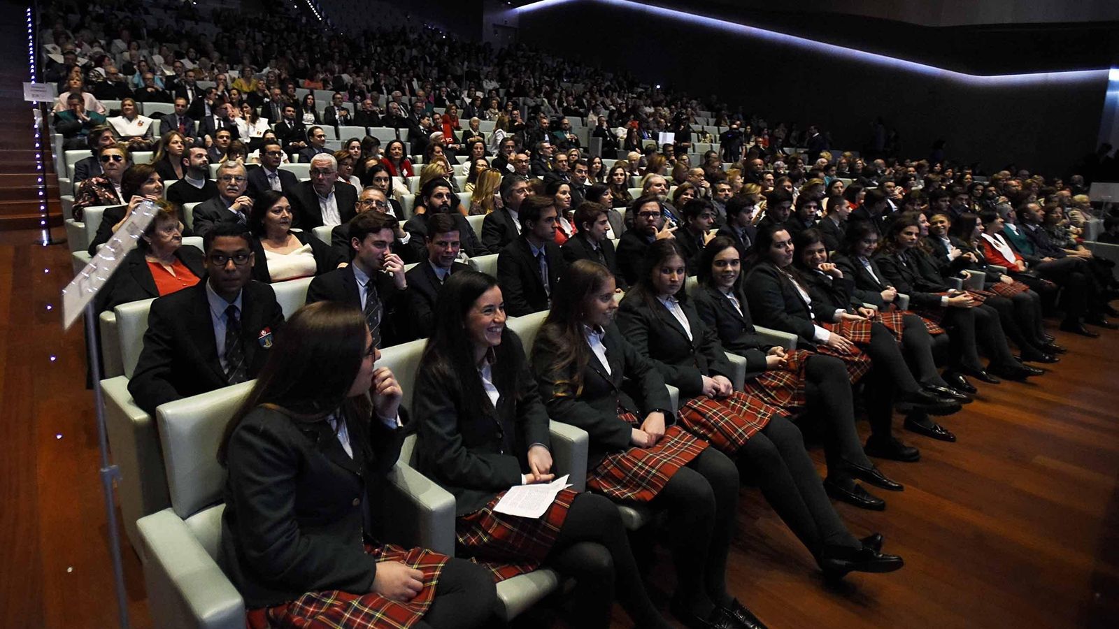 El auditorio reunió a varias generaciones de familias, en primer plano los alumnos que se gradúan.