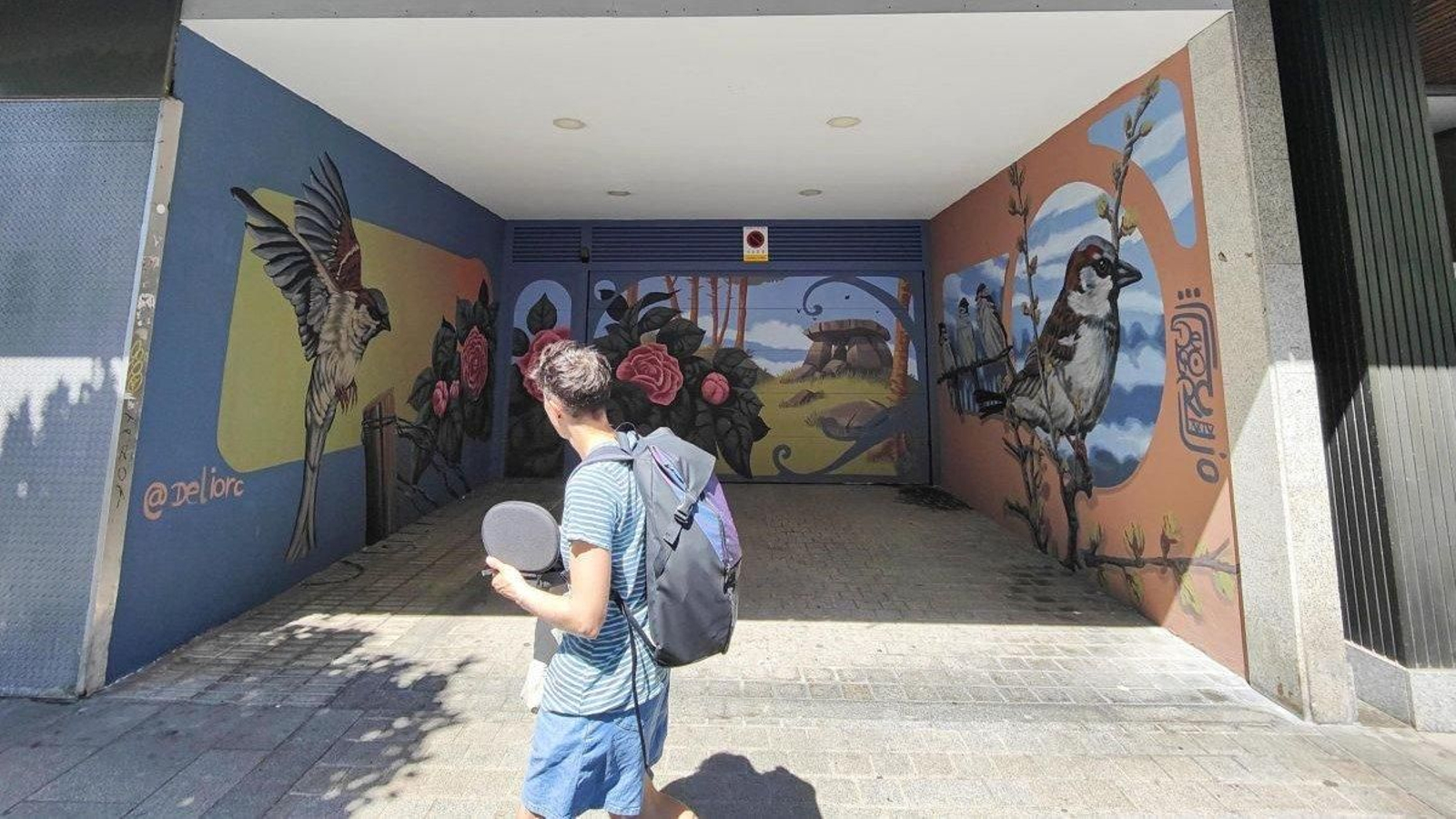Delio Rodríguez firma el nuevo mural de Camelias, en la entrada del garaje número 48.