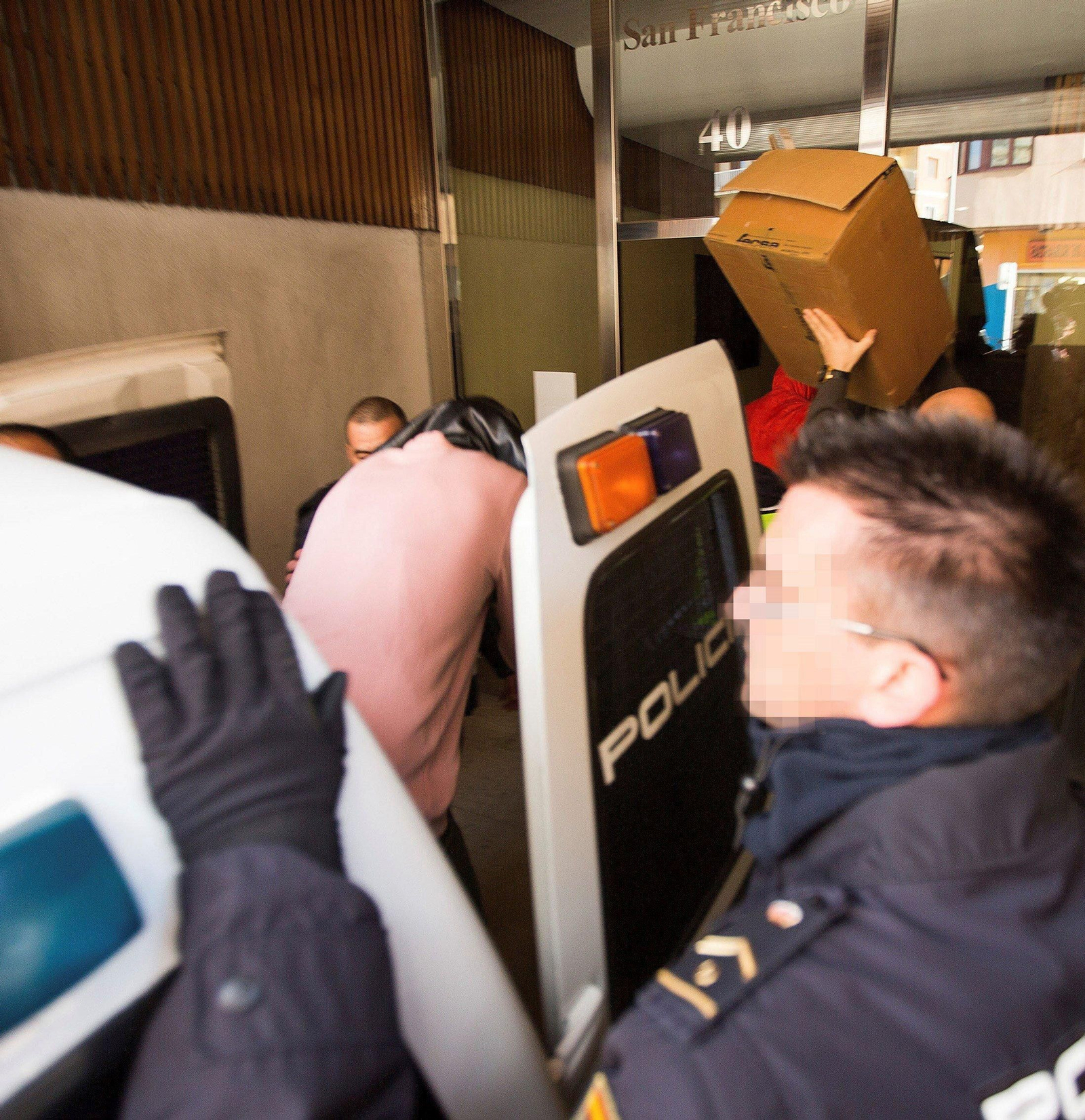 Los jugadores detenidos entran a su vivienda para el registro.
