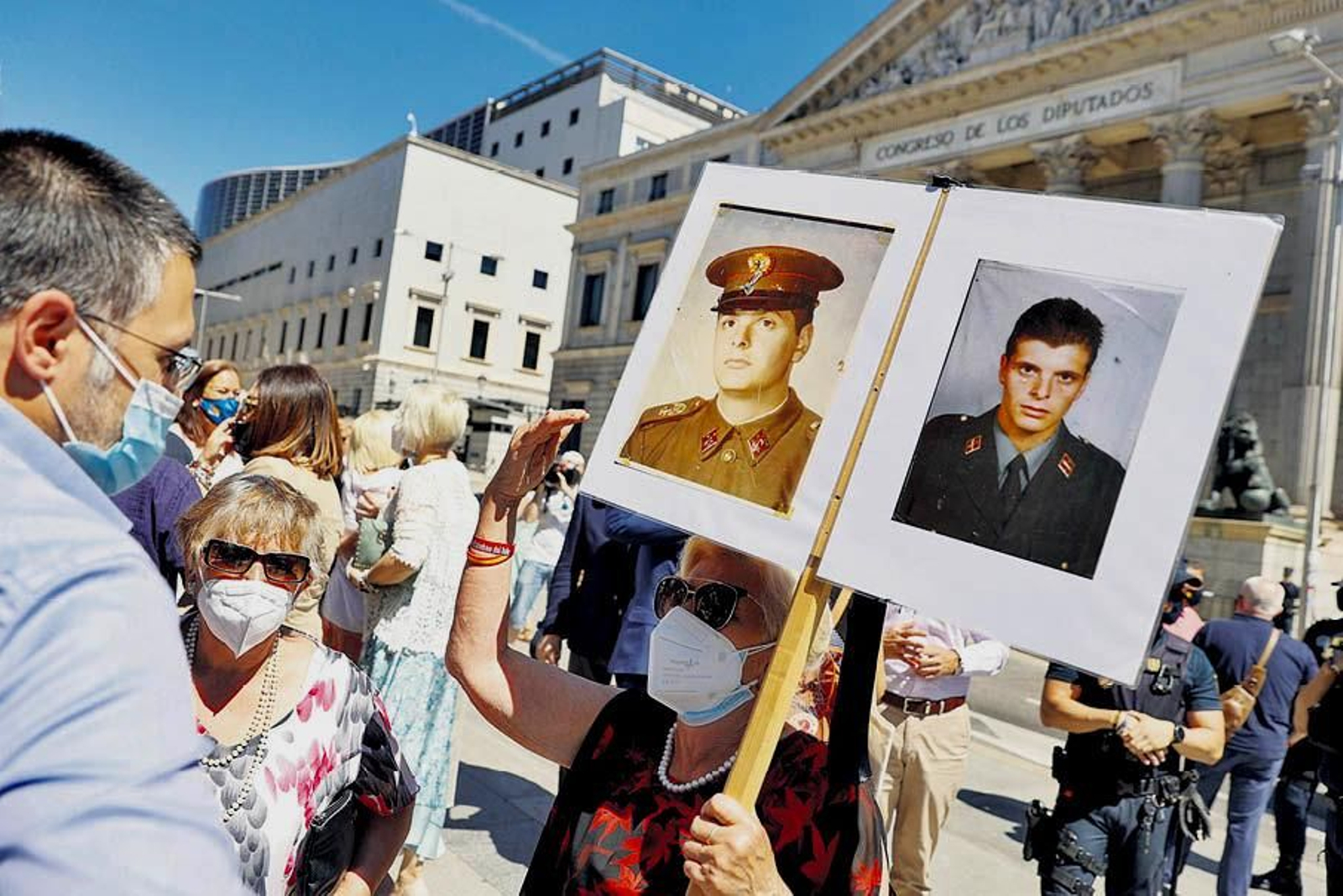 Una mujer porta un cartel con las fotos de dos agentes asesinados por ETA.