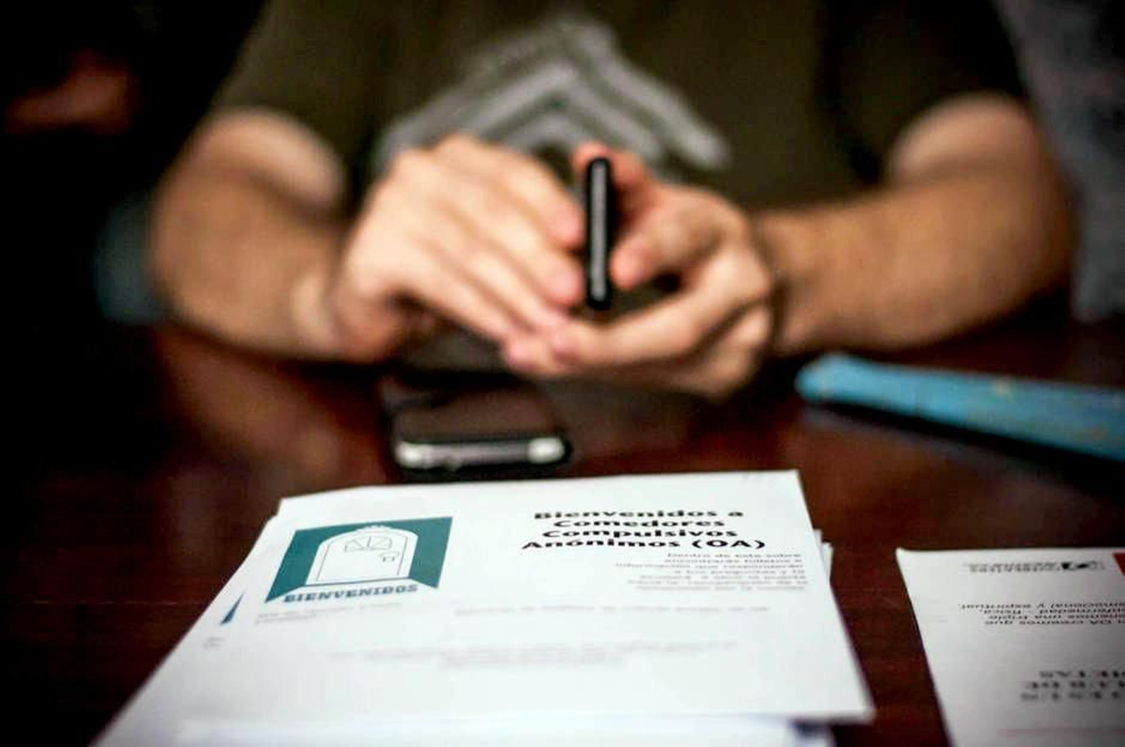 Una persona recibe un folleto informativo de una asociación de comedores compulsivos.