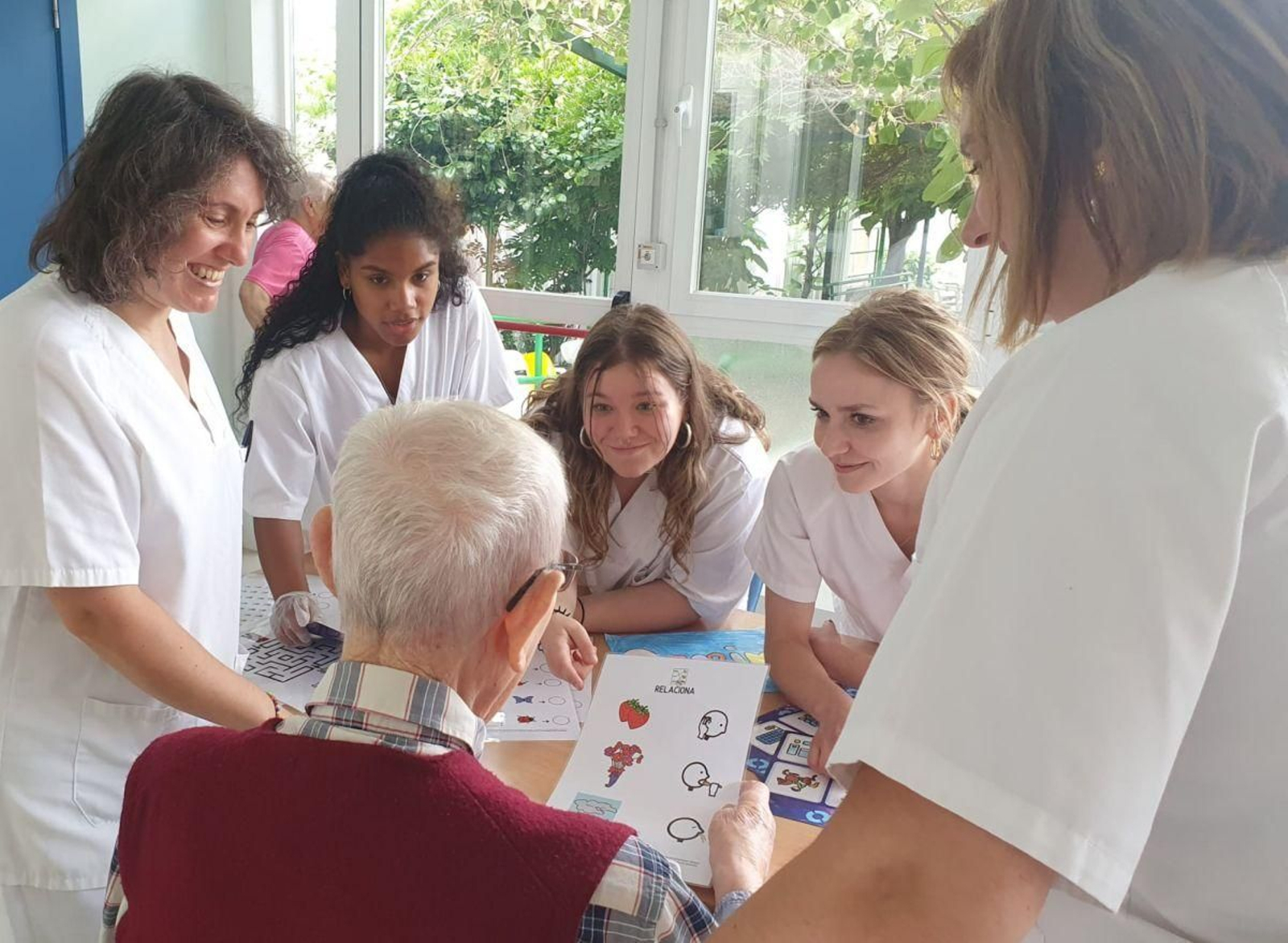 Varias alumnas atienden a un usuario de la Fundación San Rosendo.