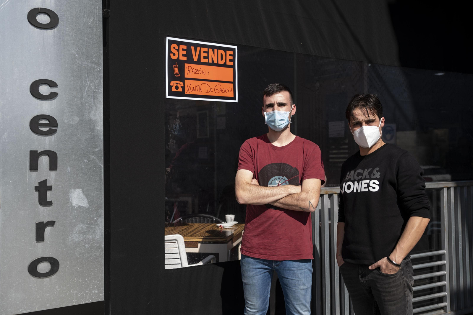 Senén y Álex posan con el cartel reivindicativo en la cafetería Acceso Centro. (Fotos: Óscar Pinal)