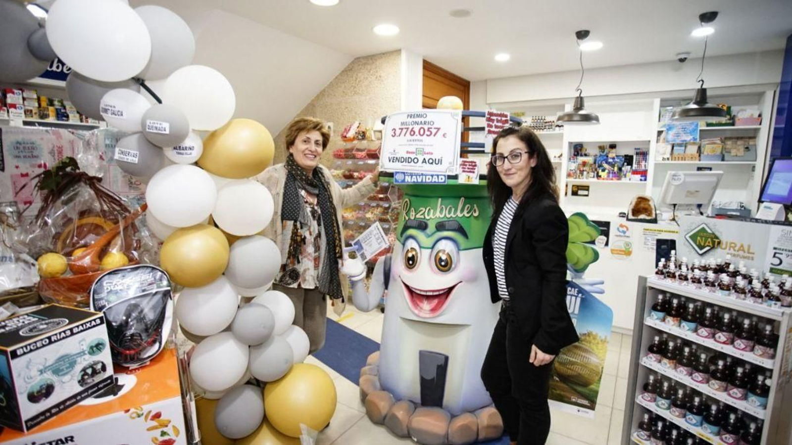 Dueñas del establecimiento muestran el cartel del premio repartido con la cuantía exacta.