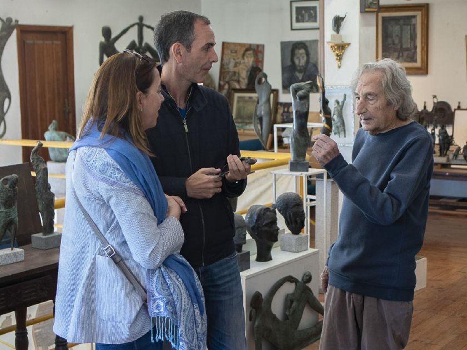 Unos visitantes conversan con Manuel Buciños, en su estudio.