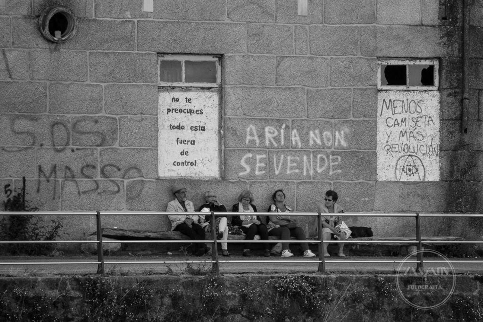 Varios vecinos charlan ante el antiguo economato de la factoría de Massó en Cangas.
