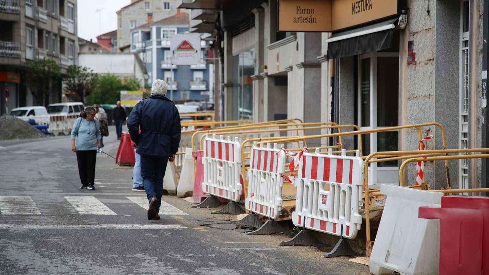 Los viandantes pasean por el asfalto de la avenida de Portugal, en una calle en estado de abandono