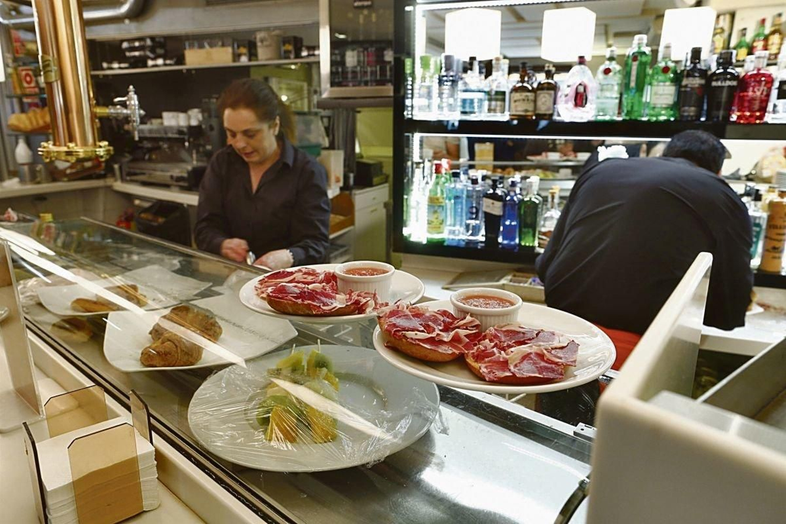 Empleados de un bar preparando un desayuno.