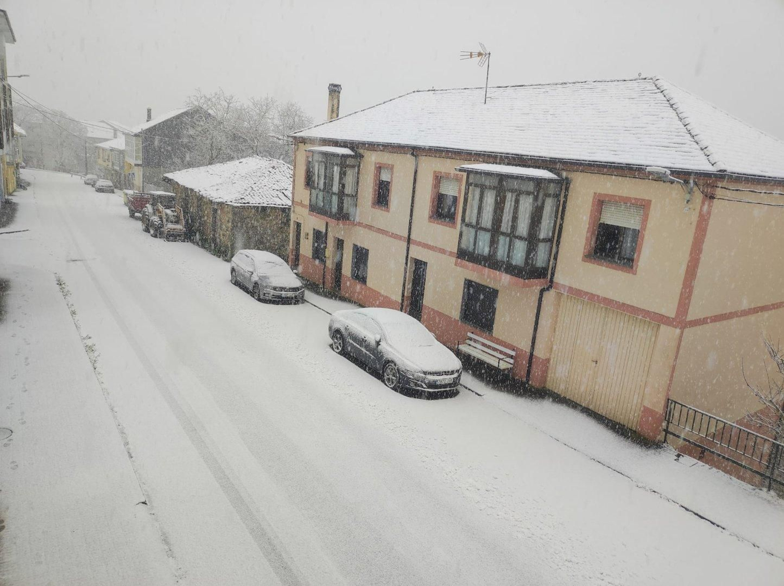 Coches y vía cubiertos por la nieve en San Xoán de Río, en Trives.