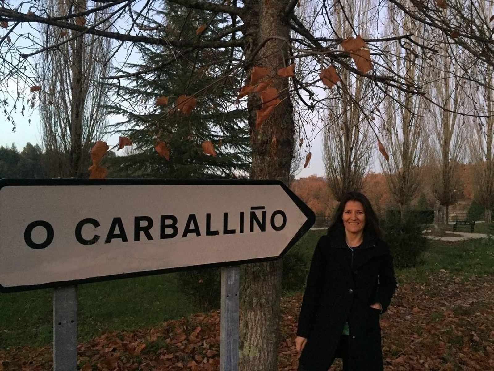 La profesora posa con el cartel de su villa natal, O Carballiño.