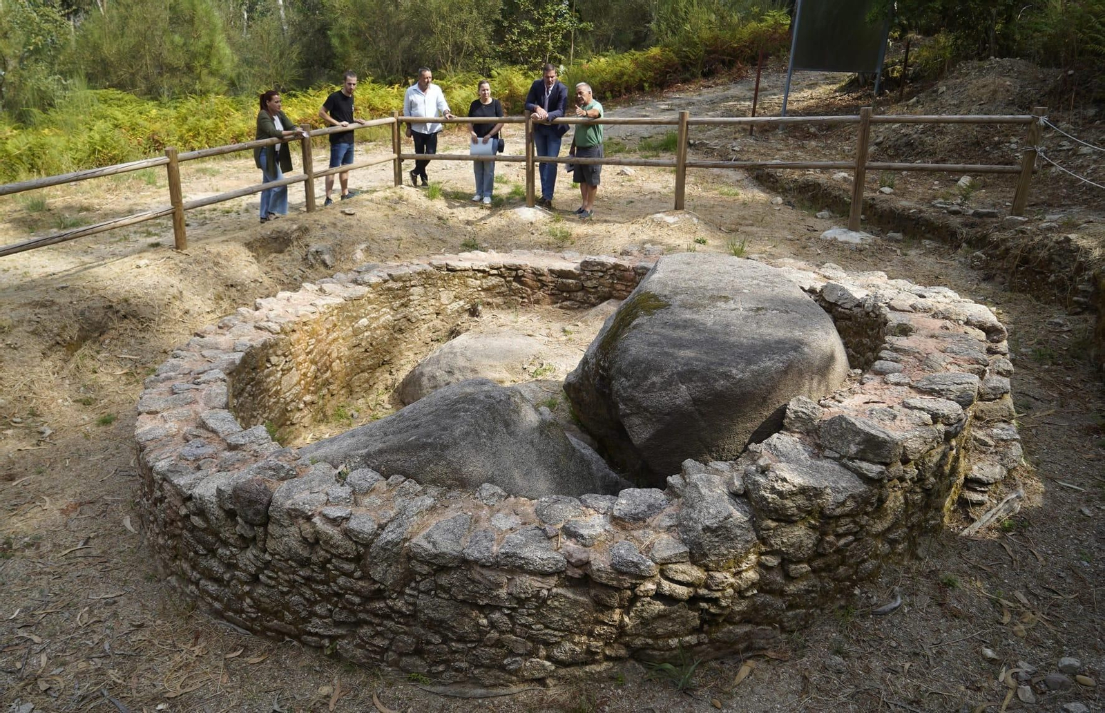 Un grupo observando una de las estructuras visibles de Os Castros.